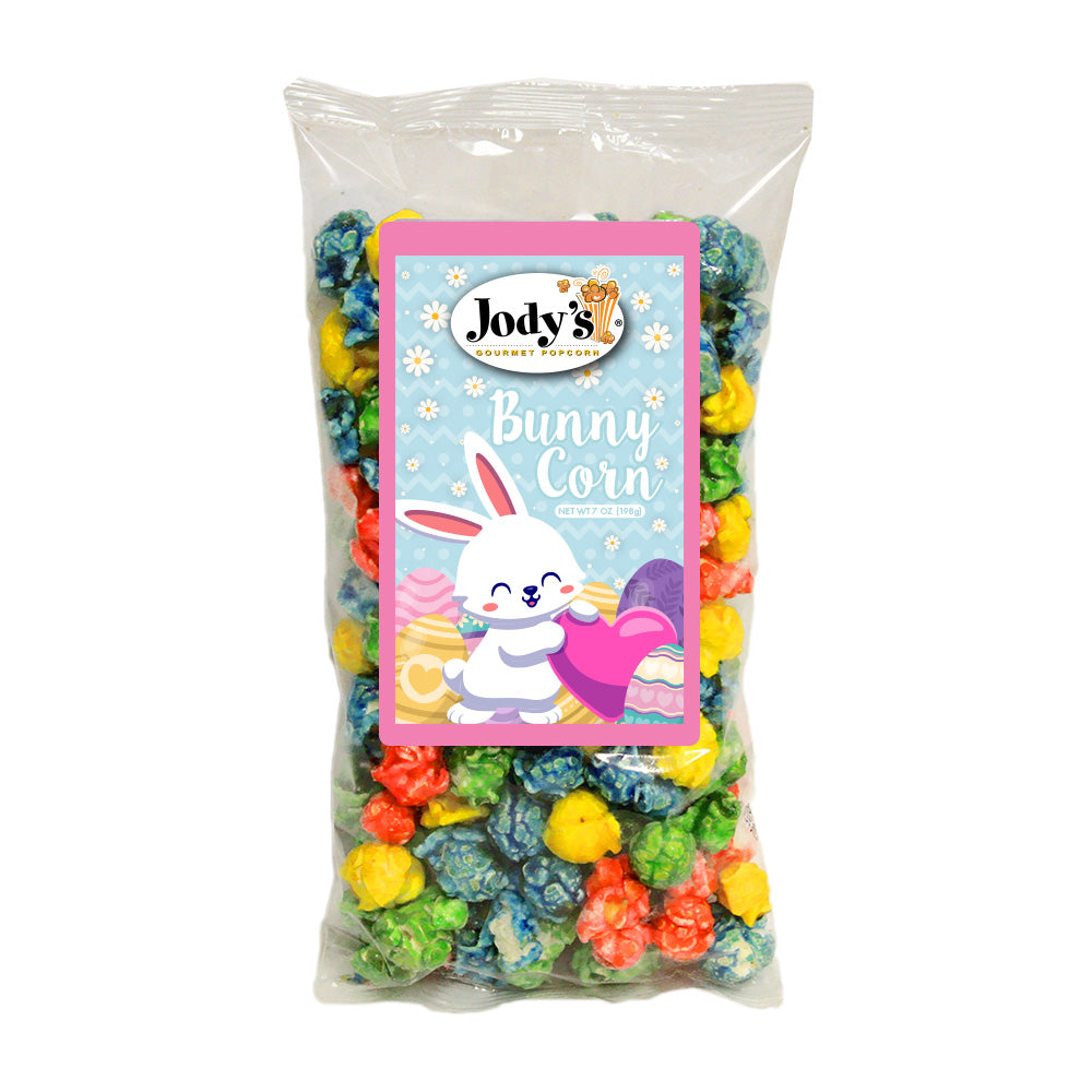 Jody’s Gourmet Popcorn Bunny Corn in a clear bag filled with colorful candy popcorn in pink, blue, and yellow, featuring a label with a smiling bunny and spring eggs.